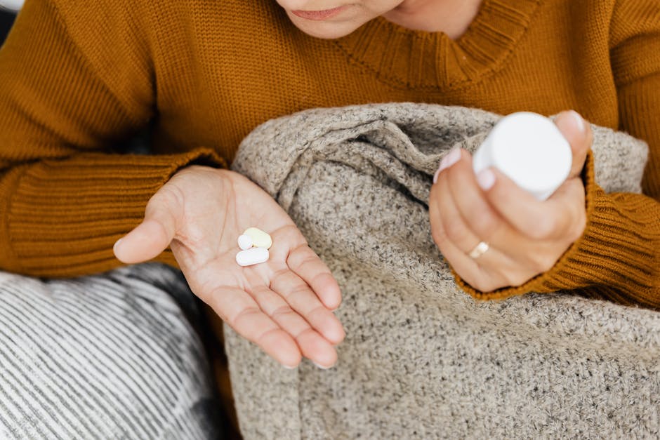 Close-up of a woman holding pills and a container in a cozy setting.