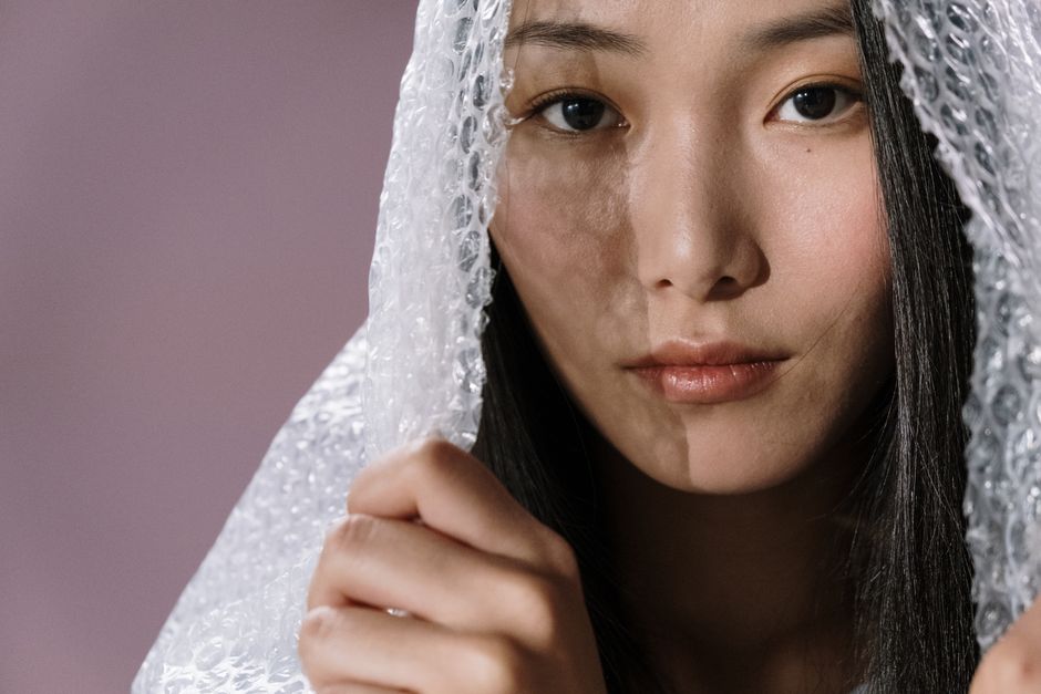 Close-up studio portrait of a woman with bubble wrap emphasizing texture and expression.