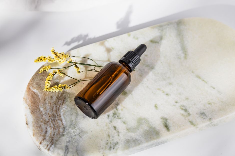 Skincare serum and moisturizer bottles on a bathroom counter