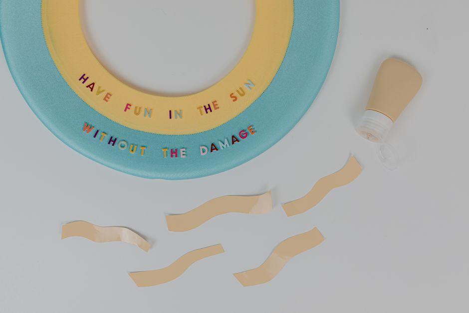 Colorful summer-themed arrangement with sunscreen and sun safety message.