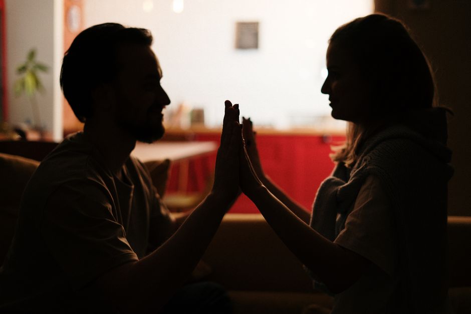 Silhouette of a couple sharing an intimate moment in a cozy home setting. Perfect for love and relationships themes.