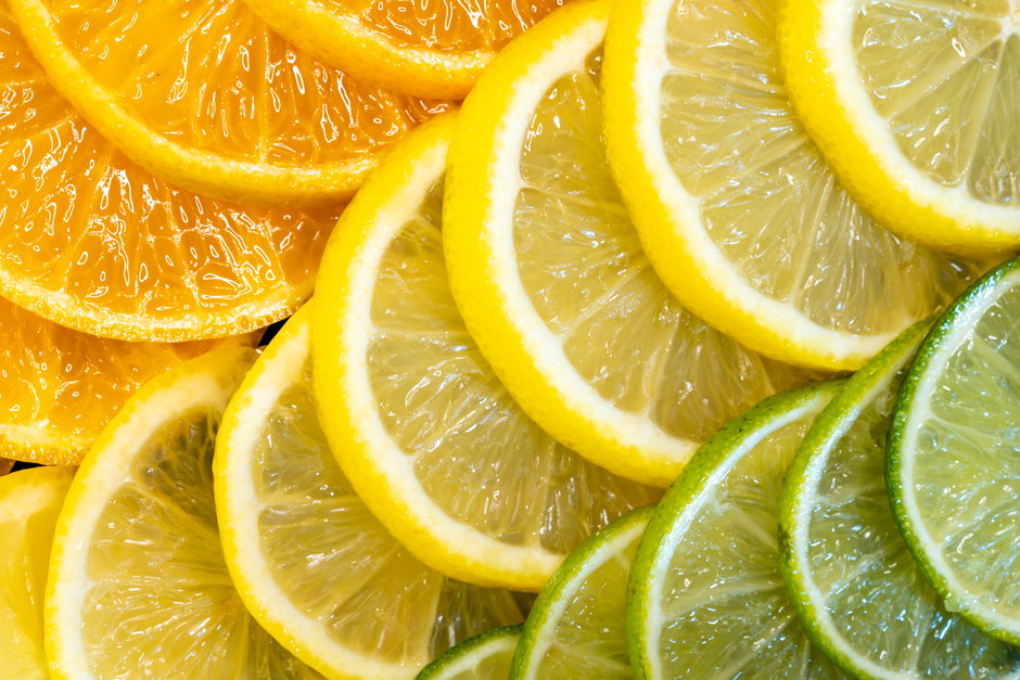 Colorful arrangement of sliced citrus fruits displaying oranges, lemons, and limes.
