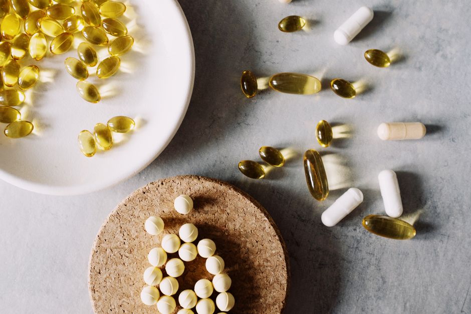 Variety of capsules and pills arranged on a marble surface. Healthcare and medicine theme.